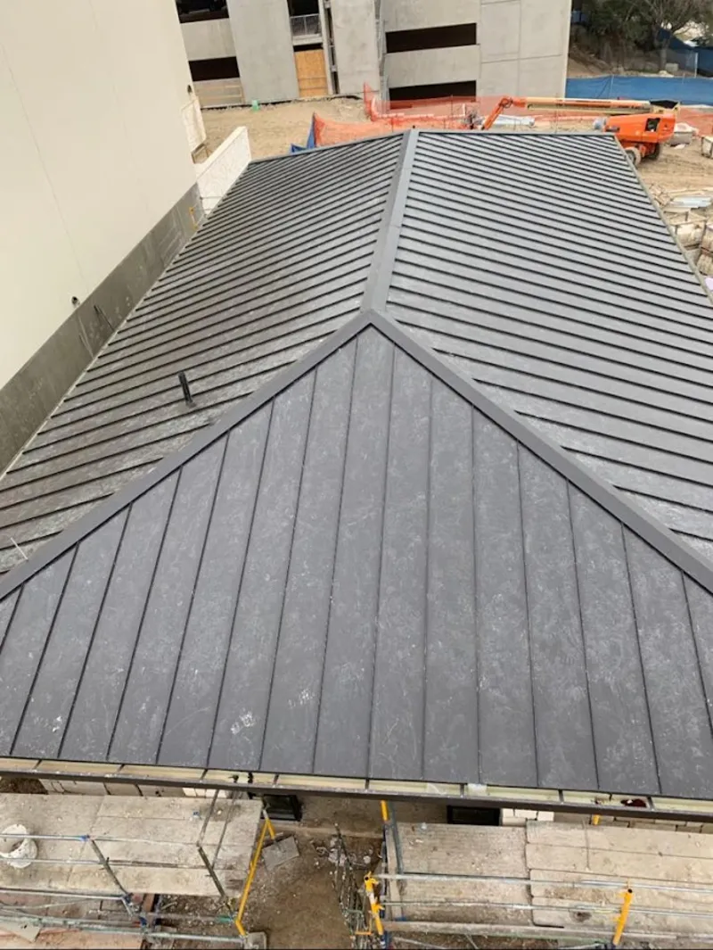 Commercial metal roof construction with crane equipment in Cheshire